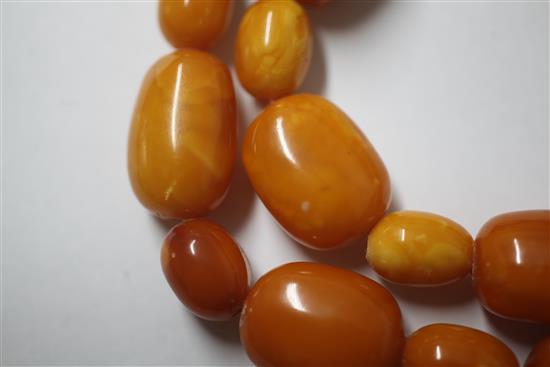 A single strand oval amber bead necklace, 104cm.